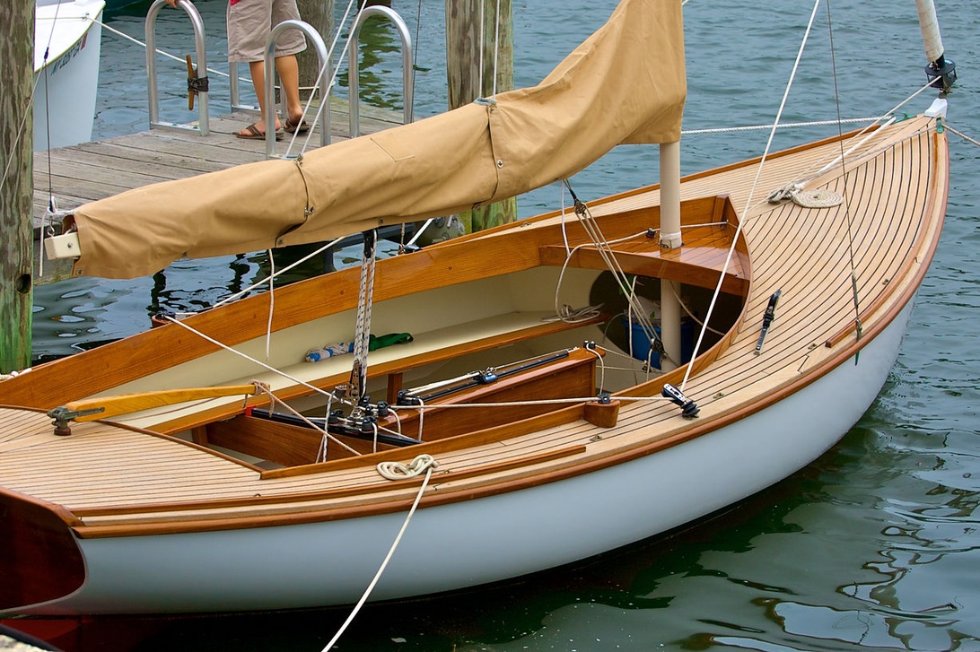 Voilier classique avec un pont en teck élégant amarré dans une marina.