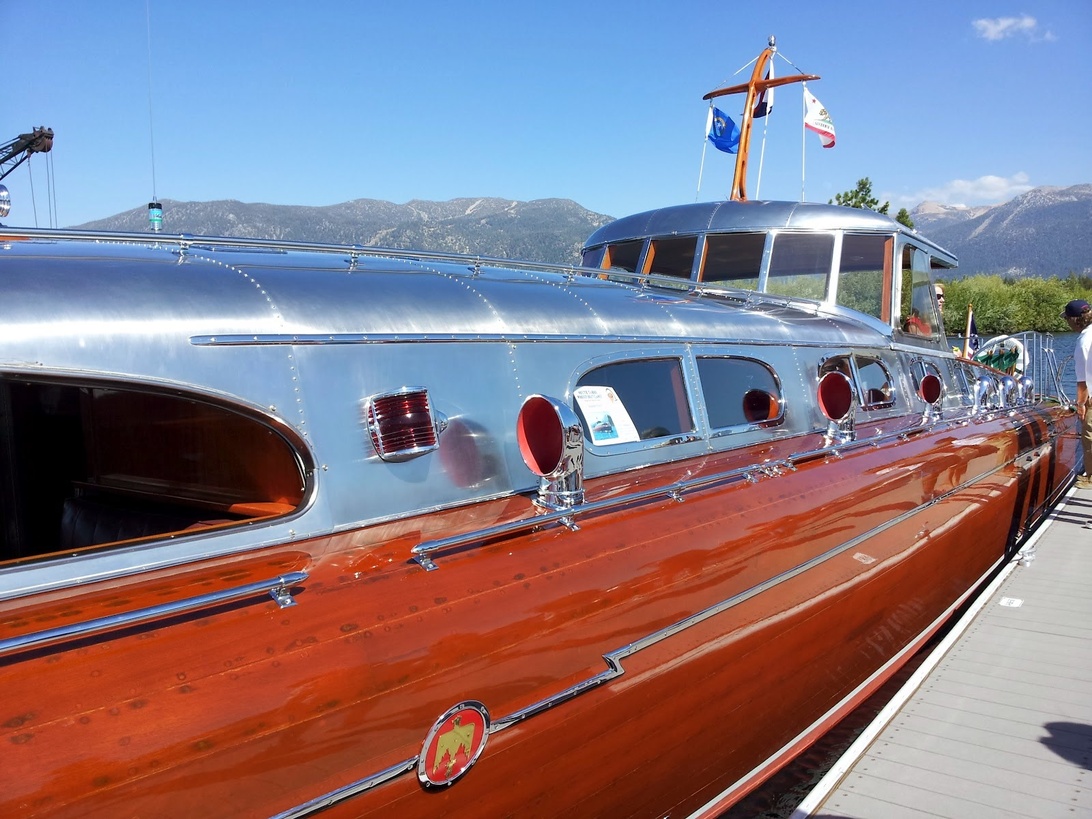 Bateau à moteur vintage avec une coque en bois poli et des hublots ronds.